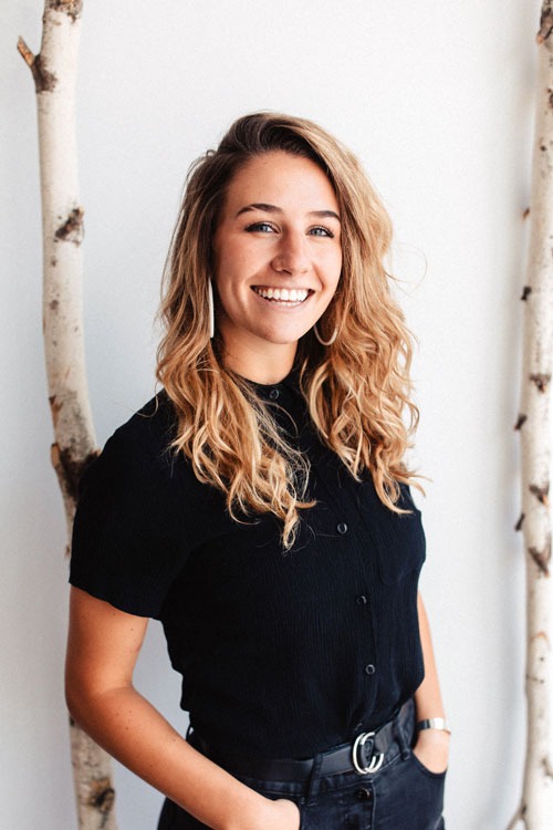 Photo of person in front of two birch trees