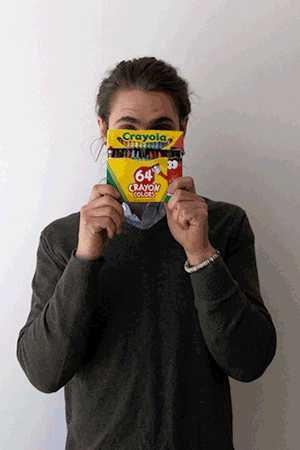 GIF of person holding a box of crayons in front of face
