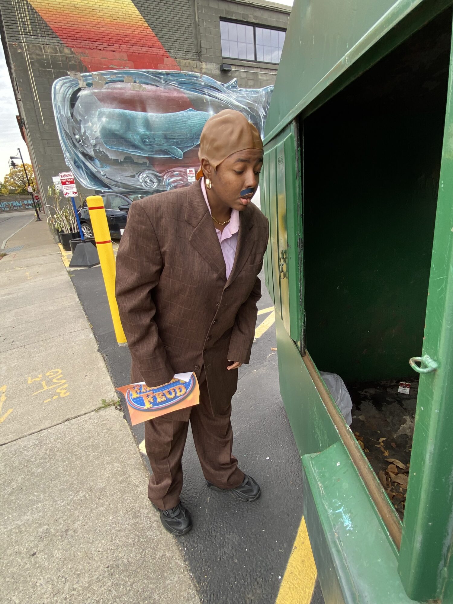 Raven as Steve Harvey blankly looks into a dumpster in a parking lot