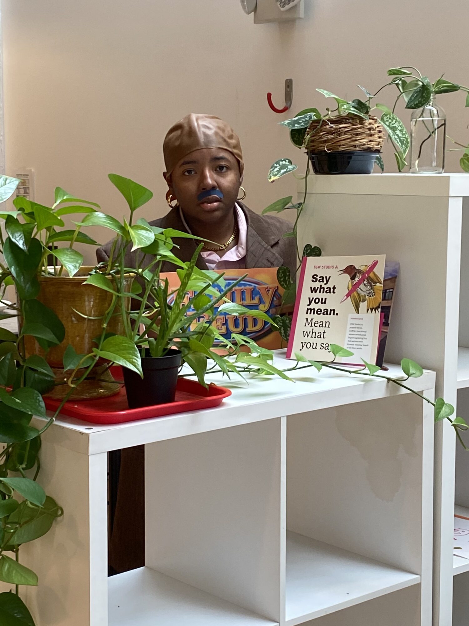 Raven as Steve Harvey hides behind house plants in the office