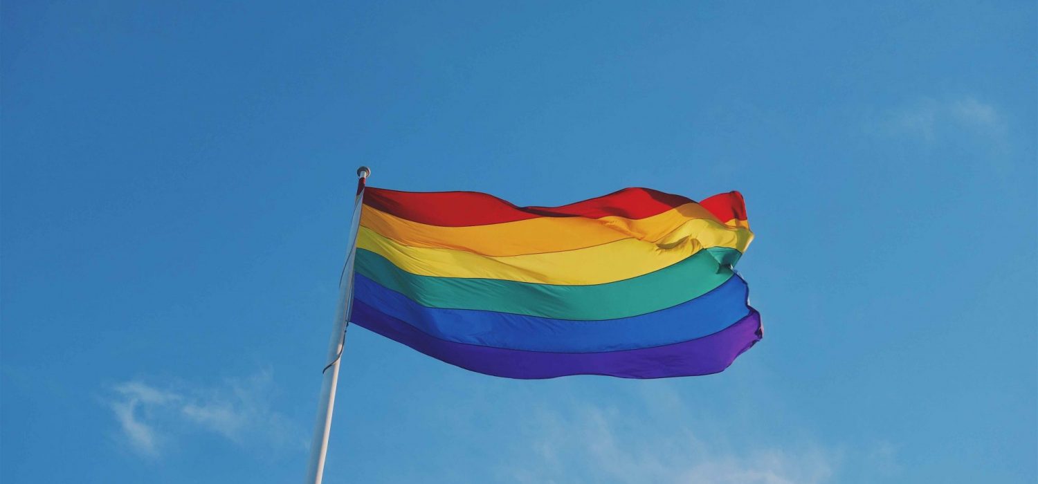 Photo of a rainbow pride flag on a flag pole