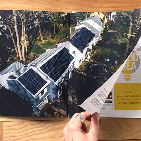 solar_family_environmental_strategy_2_tgw_studio_services Person turning the page of a booklet with a spread that shows a neighborhood with solar panels depicting social responsibility
